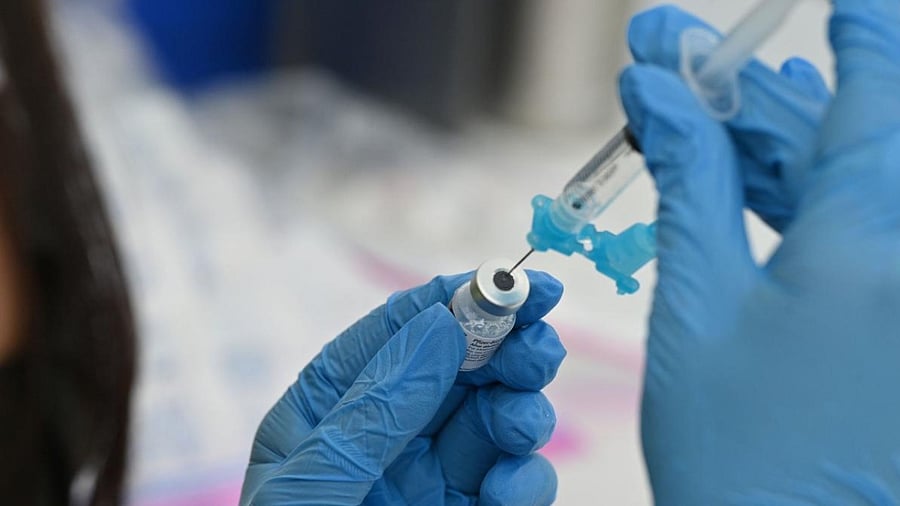A healthcare worker fills a syringe with Pfizer Covid-19 vaccine. Credit: AFP Photo