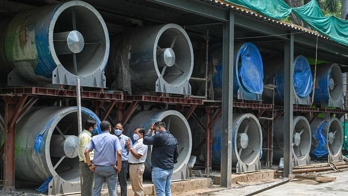 Officials talk next to large fans at the construction site of a 25-metre (82 foot) high smog tower near Connaught Place in New Delhi. Credit: AFP Photo