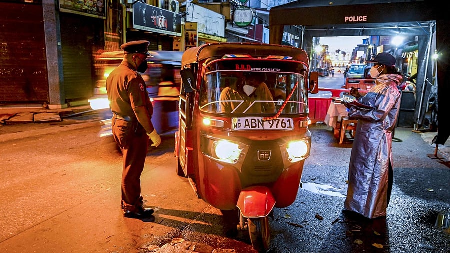 Police speak with a commuter at a checkpoint during a ten-day-long nationwide lockdown imposed to curb the spread of the Covid-19 coronavirus in Colombo on August 26, 2021. Credit: AFP Photo