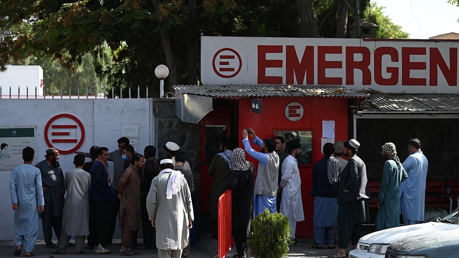 People gather outside a hospital to check on missing relatives. Credit: AFP Photo
