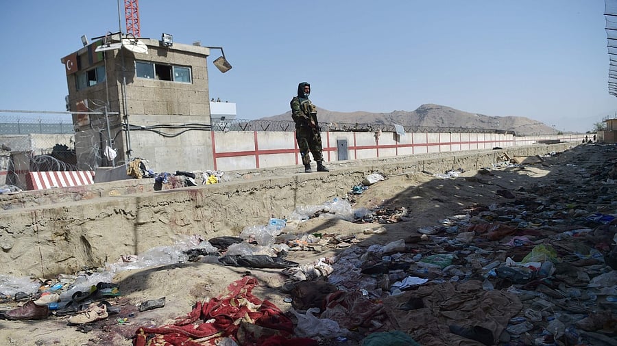 A Taliban fighter stands guard at the site of the August 26 twin suicide bombs. Credit: AFP Photo