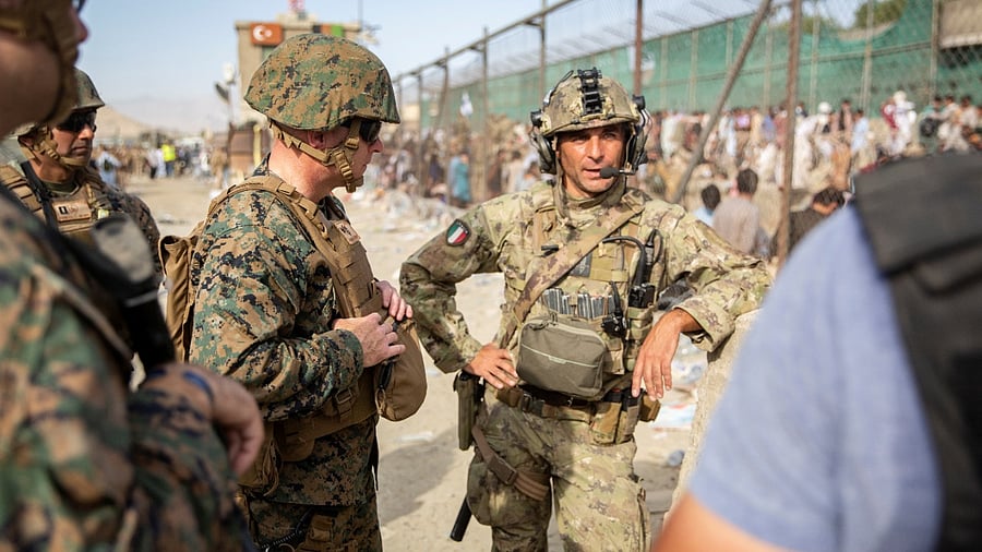 US Marine Brigadier General Farrell J. Sullivan, the commander of the Naval Amphibious Task Force 51/5th Marine Expeditionary Brigade, speaks to a service member of the Italian coalition force during an evacuation at Hamid Karzai International Airport, Kabul. Credit: Reuters photo/US Marine Corps/Staff Sgt. Victor Mancilla/Handout