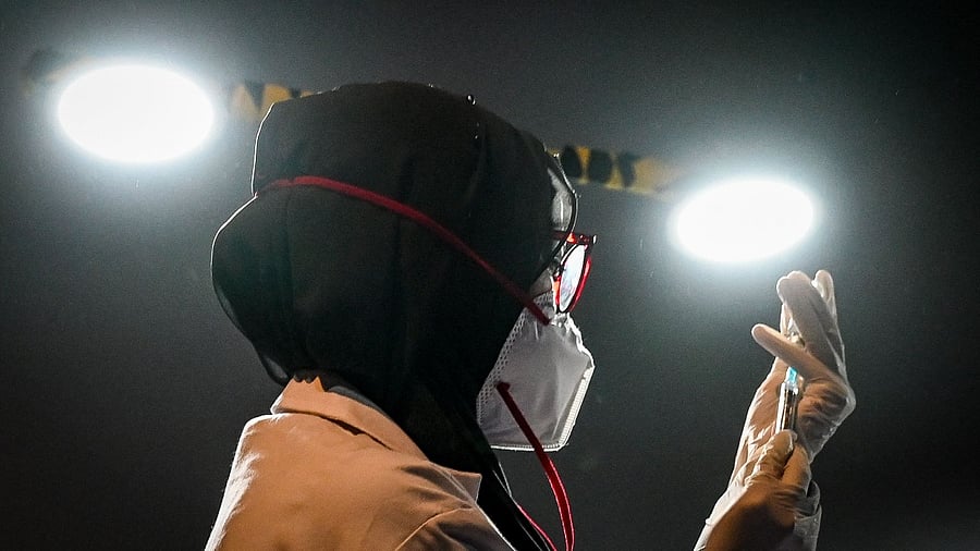 A health worker prepares a dose of the Covishield vaccine against the Covid-19 coronavirus, at a temporary vaccination centre set up inside a multiplex cinema hall complex in Mumbai on August 17, 2021. Credit: AFP File Photo