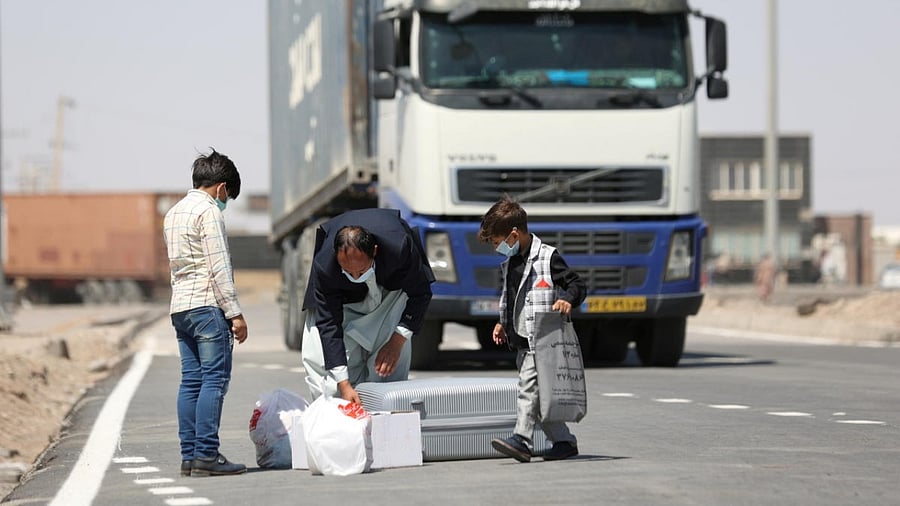 Afghan nationals stand at the Dowqarun border crossing between Iran and Afghanistan, Razavi Khorasan Province. Credit: Reuters photo/Majid Asgaripour/WANA
