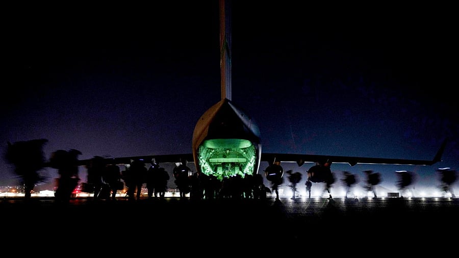 US Soldiers, assigned to the 82nd Airborne Division, prepare to board a US Air Force C-17 Globemaster III aircraft to leave Hamid Karzai International Airport in Kabul, Afghanistan. Credit: Reuters Photo