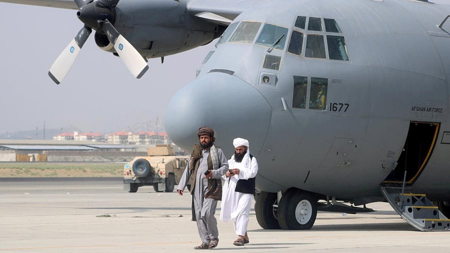 Taliban walk in front of a military airplane a day after the US troops withdrawal from Hamid Karzai International Airport in Kabul. Credit: Reuters Photo