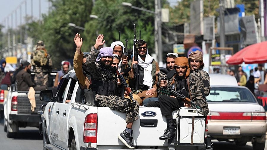 Taliban fighters wave as they patrol in a convoy along a street in Kabul. Credit: AFP Photo