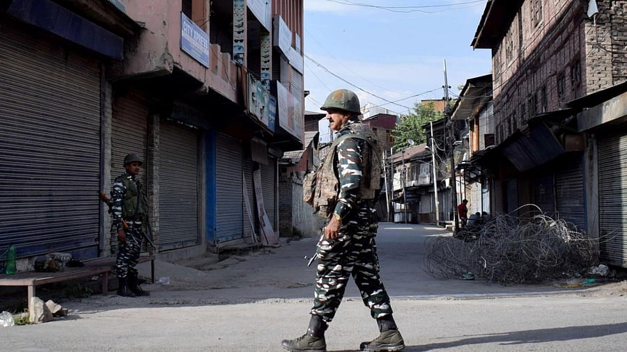 Indian security forces personnel stand guard in front of closed shops during restrictions imposed by authorities following the death of Syed Ali Shah Geelani in Srinagar. Credit: Reuters Photo
