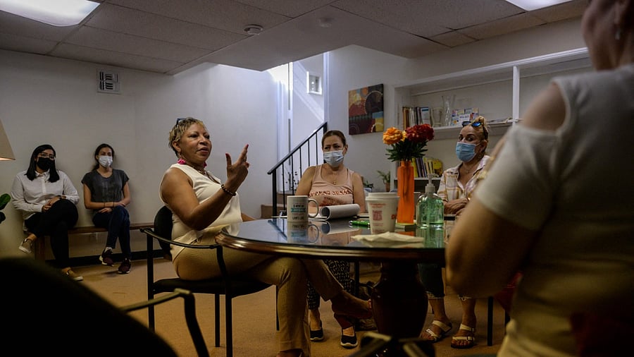 Clinical social worker Rosa Bramble (C) of 'Borders for Hope' sits with clients during a group meeting for immigrant ground zero clean-up workers. Credit: AFP Photo