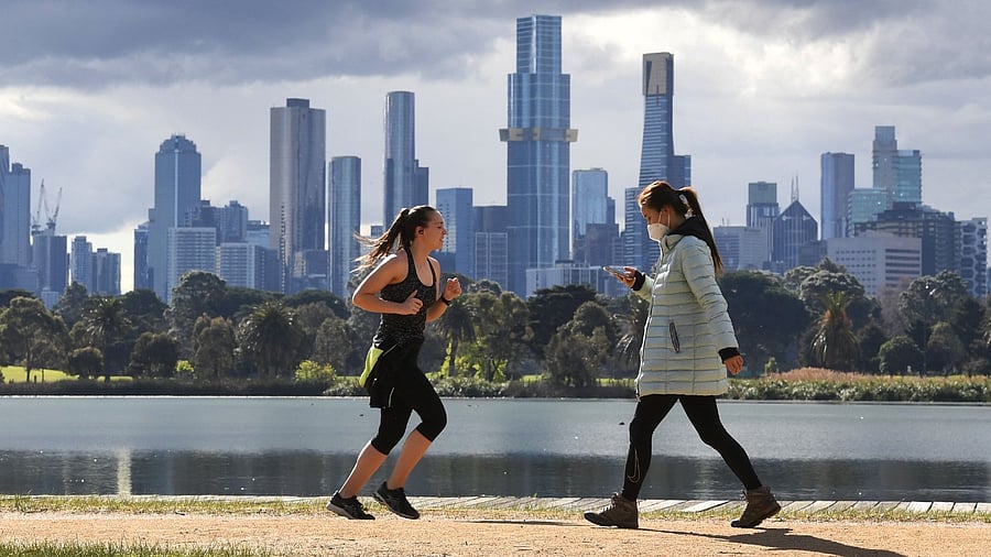 People exercise in front the city skyline in Melbourne on August 29, 2021, as authorites announced the extension of an ongoing coronavirus lockdown in Australia's second-biggest city. Credit: AFP Photo