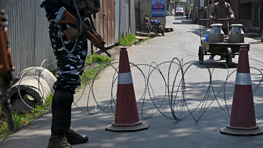 An Indian paramilitary trooper (L) stands guard in the Eidgah area of Srinagar. Credit: AFP Photo