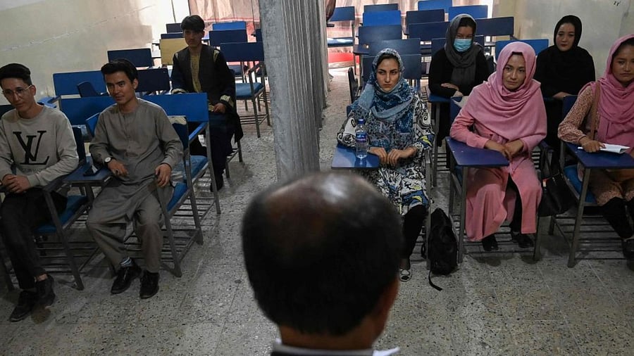 Students attend a class bifurcated by a curtain separating males and females at a private university in Kabul on September 7, 2021, to follow the Taliban's ruling. Credit: AFP Photo