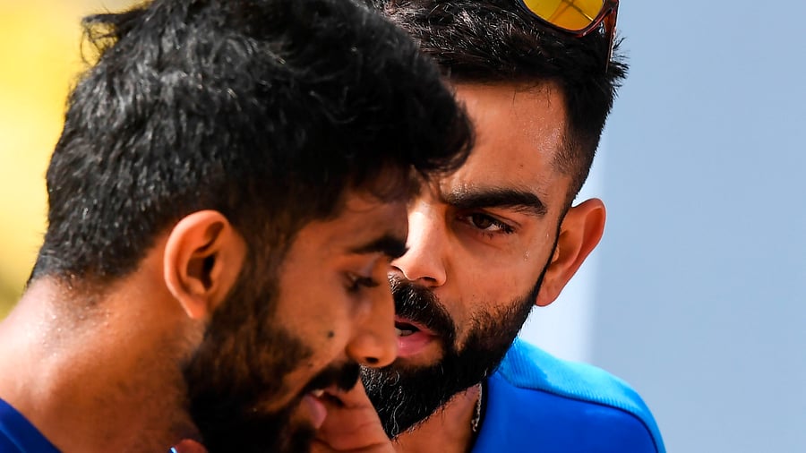 India's captain Virat Kohli (R) talks with Jasprit Bumrah. Credit: AFP Photo