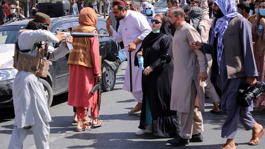 A member of the Taliban forces points his gun at protesters, as Afghan demonstrators shout slogans during an anti-Pakistan protest, near the Pakistan embassy in Kabul, Afghanistan. Credit: Reuters Photo