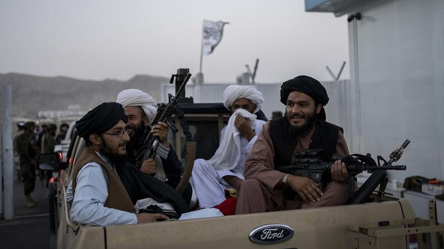 Taliban fighters sit in a pickup truck at the airport in Kabul, Afghanistan. Credit: AFP Photo