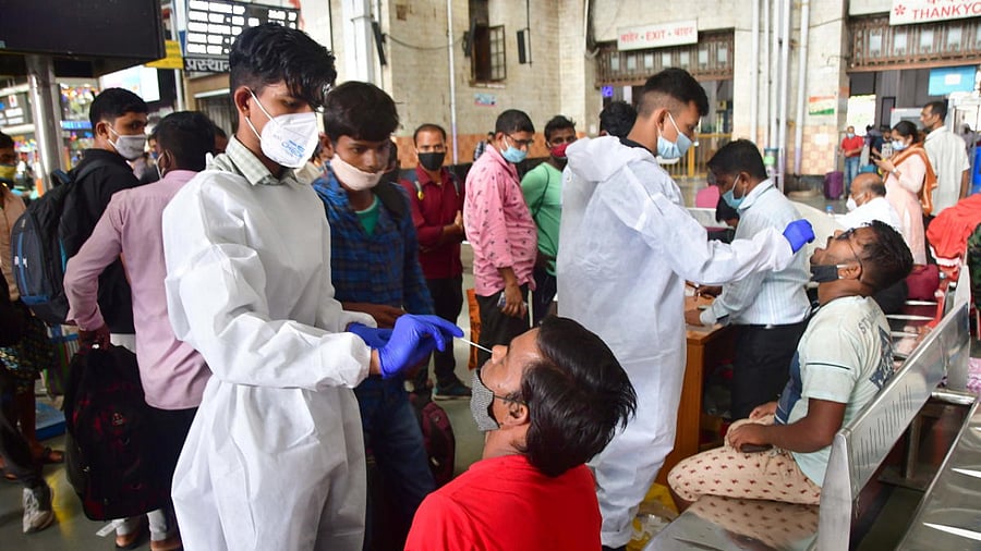 BMC health workers collect swab samples from passengers for Covid-19 testing at CSMT Railway Station in Mumbai. Credit: PTI Photo