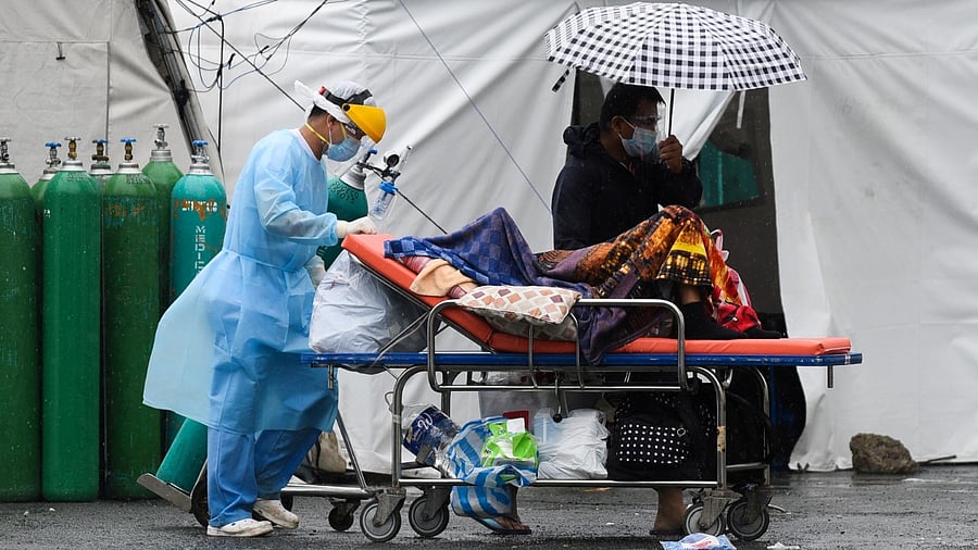 A health worker wearing personal protective equipment (PPE) transports a suspected Covid-19 patient, at Sta. Ana Hospital, in Manila, Philippines. Credit: Reuters File Photo