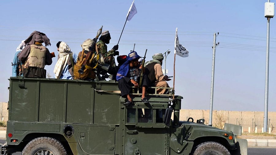 Taliban fighters stand on an armoured vehicle before parading along a road to celebrate after the US pulled all its troops out of Afghanistan, in Kandahar. Credit: AFP Photo