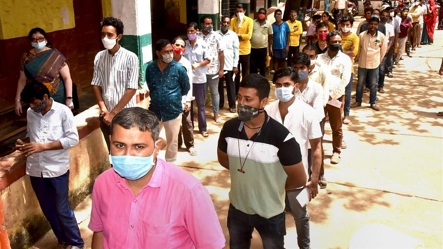Beneficiaries wait in queues to receive Covid-19 vaccine dose, in Hubballi. Credit: PTI photo
