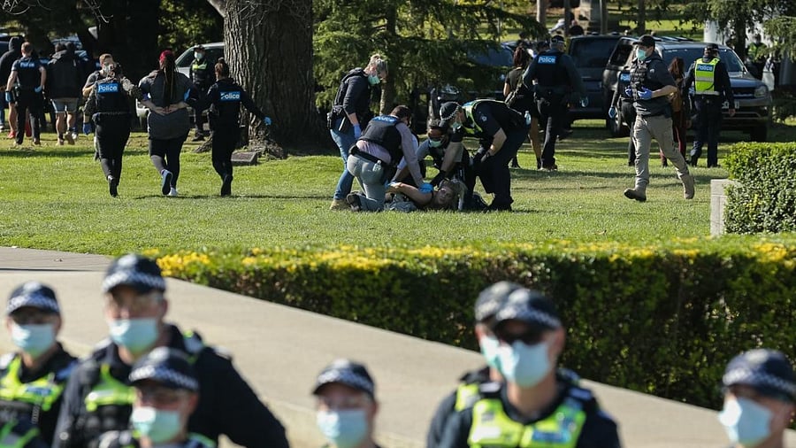 Police detain people as construction workers and demonstrators on the steps of the Shrine of Remembrance protest against Covid-19 regulations in Melbourne. Credit: AFP Photo