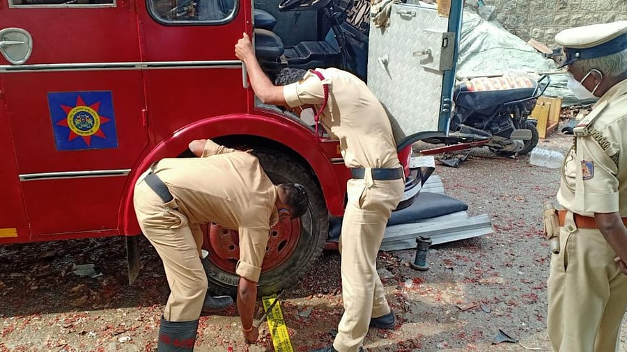 Firemen trying to change the front wheel of the fire fighting truck which turned flat while reaching the spot. Credit: DH Photo