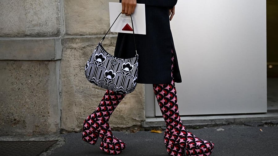 A guest arrives at the location of Prada's Women's Spring-Summer 2022 collection presentation during the Fashion Week in Milan. Credit: AFP Photo