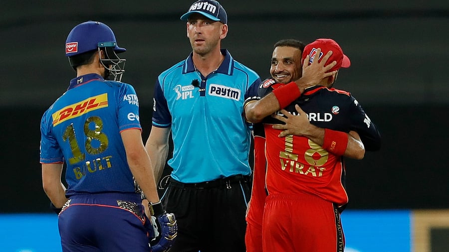 Harshal Patel of Royal Challengers Bangalore celebrates the wicket with Virat Kohli during match 39 of the Indian Premier League between the Royal Challengers Bengaluru and Mumbai Indias, held at the Dubai International Stadium in the United Arab Emirates, Sunday. Credit: PTI Photo