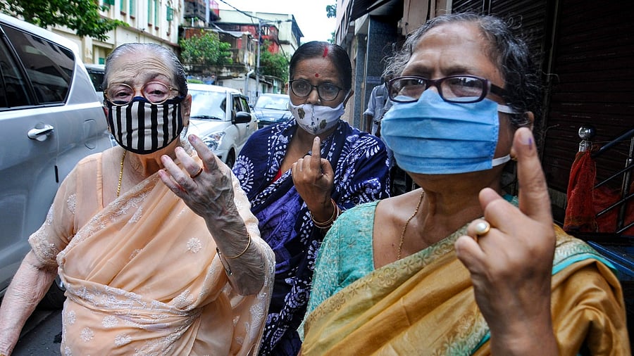 Citizens show their fingers marked with indelible ink after casting their votes during the by-election to the Bhabanipur assembly constituency. Credit: PTI Photo