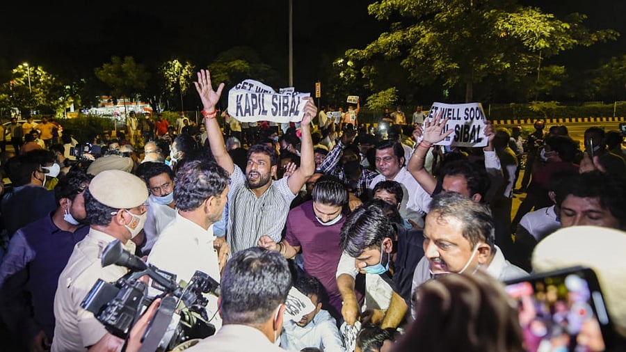 Delhi Congress workers hold placards reading 'Get Well Soon Kapil Sibal' stage a protest against senior party leader Kapil Sibal outside his residence, hours after Sibal reiterated demands sweeping reforms raised by G-23 leaders, in New Delhi, Wednesday, Sept. 29, 2021. Credit: PTI Photo
