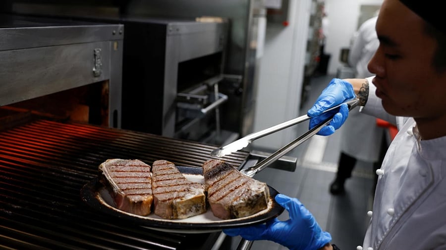A chef cooks beef steaks at the kitchen of Wolfgang's Steakhouse restaurant, in Beijing. Credit: Reuters Photo