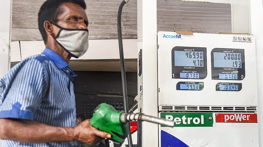 An attendant of a fuel station works, as petrol price nears the 100 rupees mark after a fresh hike in fuel prices. in Mumbai. Credit: PTI Photo