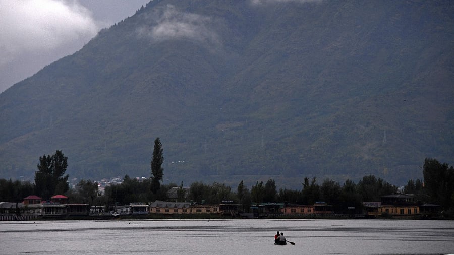 Men take a boat ride in Dal Lake as it rains in Srinagar on October 11, 2021. Credit: AFP Photo