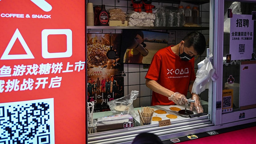 A man in a shop making dalgona candy, featured in Squid Game, in Shanghai. Credit: AFP Photo