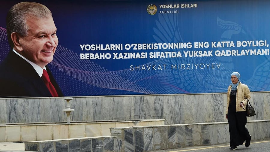 A woman walks past a campaign billboard of Uzbekistan's President and presidential candidate Shavkat Mirziyoyev in Tashkent. Credit: AFP Photo