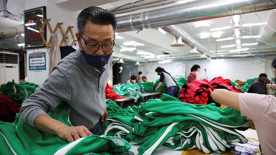 Ko Jong-hyun, 59, a clothing factory owner, checks newly made tracksuits inspired by Netflix series "Squid Game" at his plant in Seoul. Credit: Reuters Photo