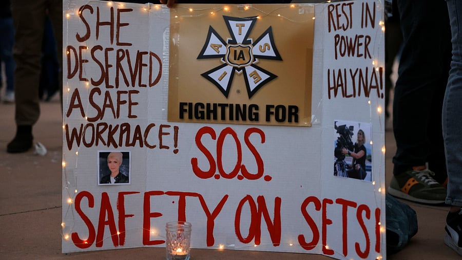 A woman displays a sign calling for workplace safety at a vigil for cinematographer Halyna Hutchins, who died after being shot by Alec Baldwin on the set of his movie "Rust", in Albuquerque. Credit: Reuters Photo
