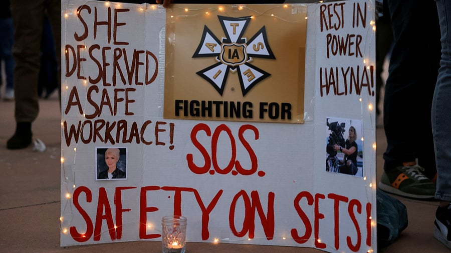 A woman displays a sign calling for workplace safety at a vigil for cinematographer Halyna Hutchins, who died after being shot by Alec Baldwin on the set of his movie "Rust", in Albuquerque, New Mexico, October 23. Credit: Reuters File Photo