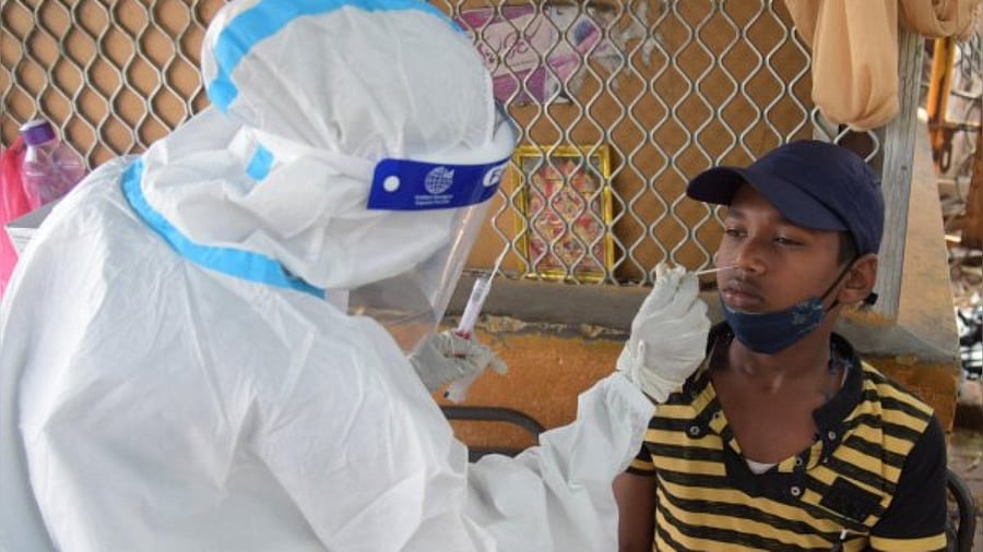 A health worker collects samples for Covid test at Majestic in Bengaluru on Wednesday. Credit: DH Photo/Pushkar