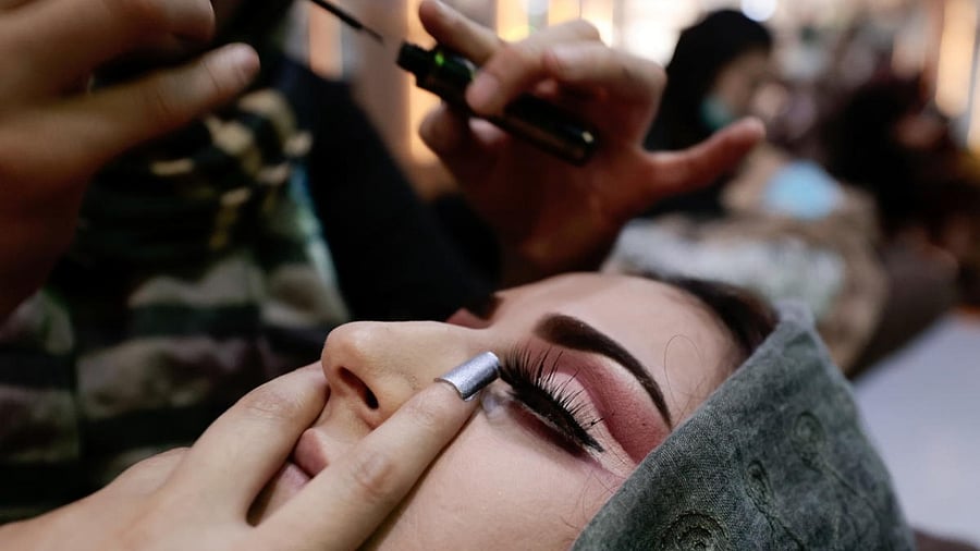 A woman has her make-up done as she prepares to attend a wedding in Kabul. Credit: Reuters Photo