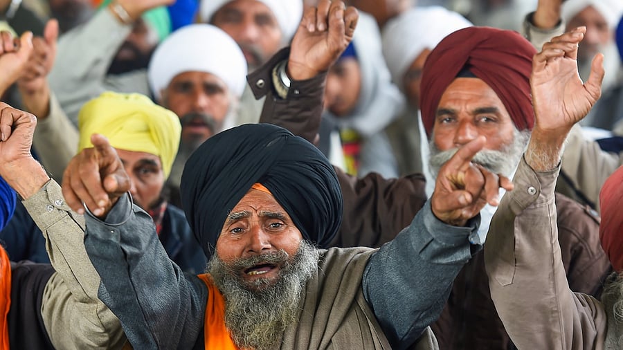 Farmers raise slogans during their ongoing agitation against Centre's farm reform laws, at Singhu border. Credit: PTI File Photo
