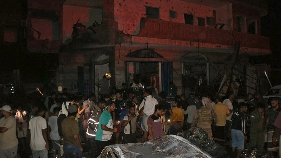Yemeni emergency service staff and bystanders gather at the site of a blast near the airport of the southern city of Aden. Credit: AFP Photo