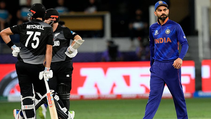 India's captain Virat Kohli (R) walks past New Zealand's captain Kane Williamson (2L) and Daryl Mitchell. Credit: AFP Photo