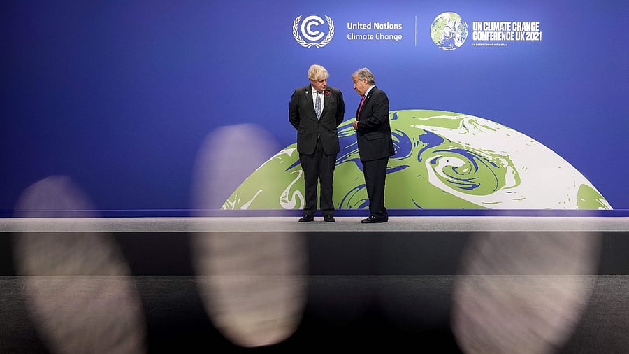Britain's Prime Minister Boris Johnson (L) and United Nations (UN) Secretary General Antonio Guterres wait to greet leaders as they arrive to attend the COP26 UN Climate Change Conference in Glasgow. Credit: AFP Photo