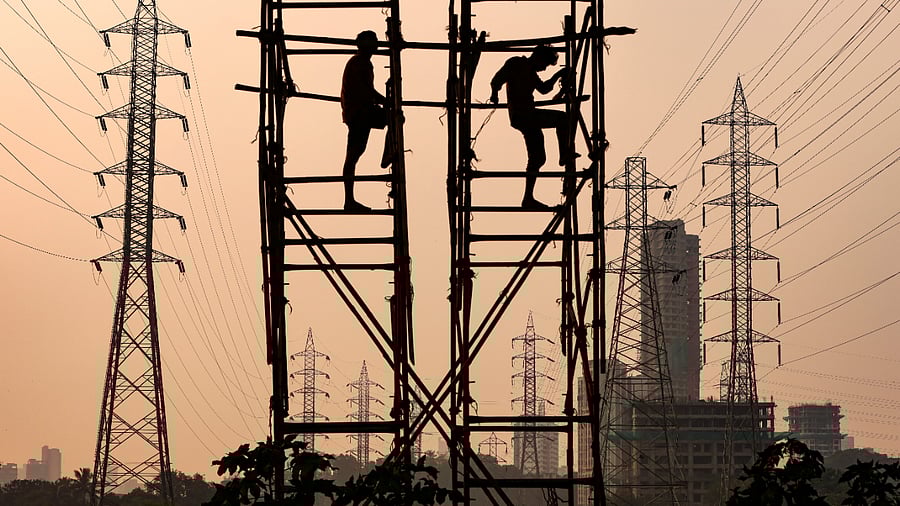 Labourers work next to electricity pylons in Mumbai. Credit: Reuters Photo