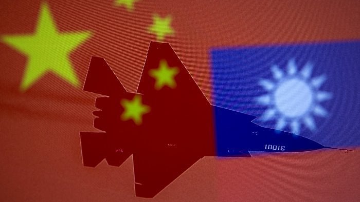 Chinese and Taiwanese national flags are displayed alongside a military airplane. Credit: Reuters File Photo