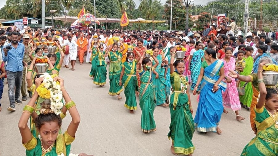Girls carry holy water as part of Halurave utsav at Male Mahadeshwara Hill in Chamarajanagar district on Thursday. Credit: DH Photo