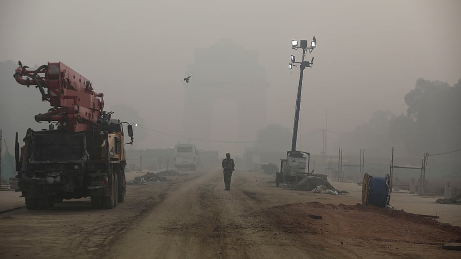 An Indian paramilitary soldier walks near India Gate which is shrouded in smog, in New Delhi. Credit: Reutest Photo