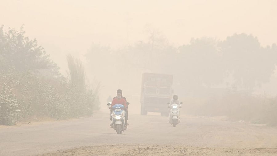 Commuters make their way amid low visibility due to heavy smog, at Dwarka expressway in Gurugram. Credit: PTI Photo