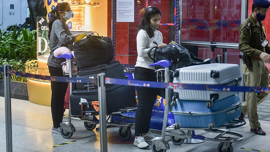 Passengers wait in a queue at the Terminal 3 of the IGI Airport to board a flight for the US. Credit: PTI Photo
