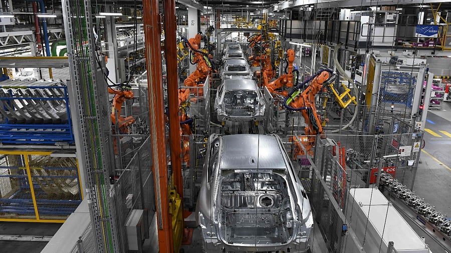Robots work on cars at an assembly line in the BMW plant in Munich. Credit: AFP File Photo